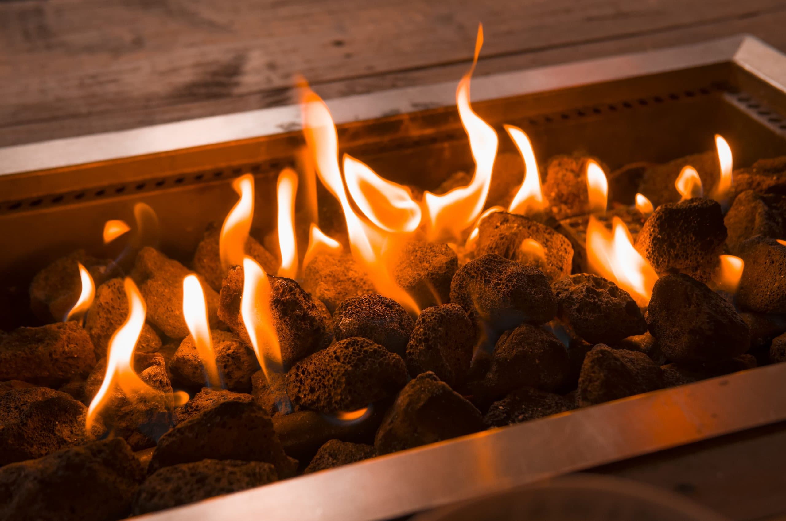 Lava rocks alight in a rectangular gas firepit burner
