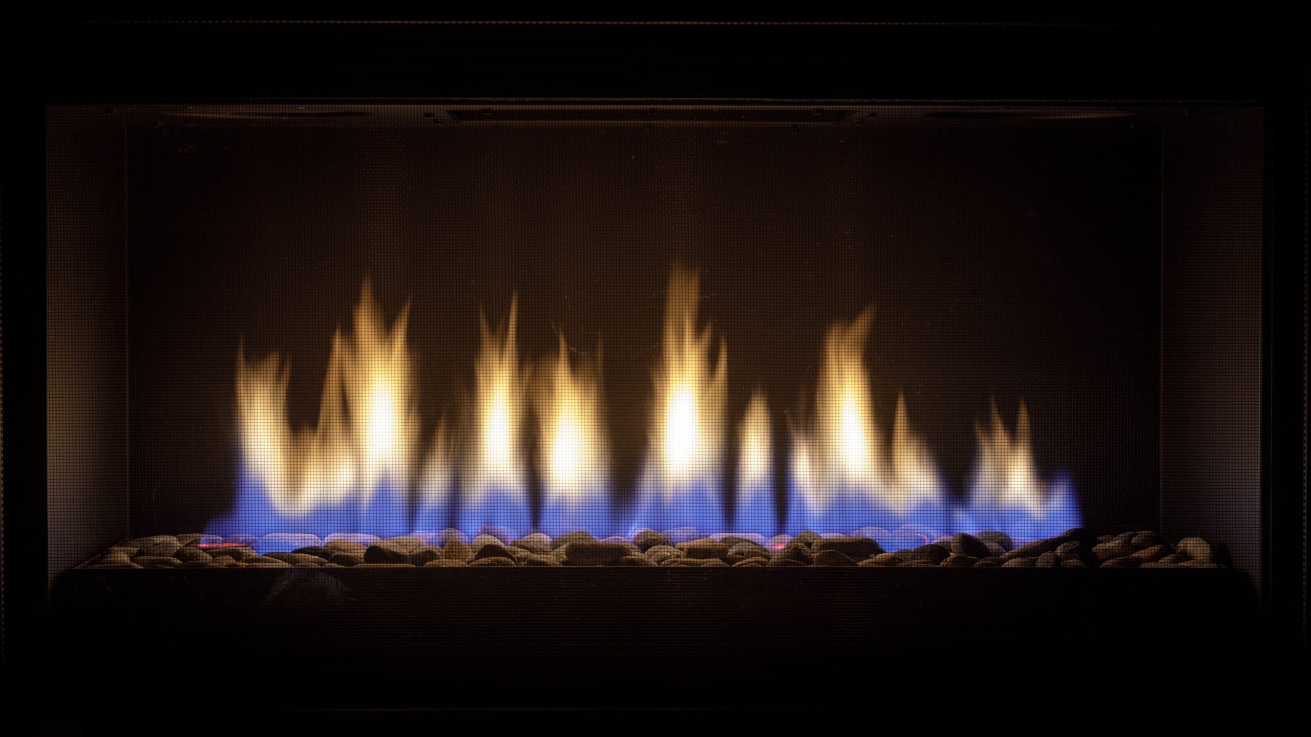 Direct vent gas fireplace alight over a bed of stones