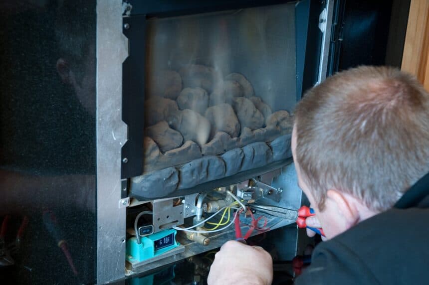 Technician working on the burner and controls of a gas fireplace