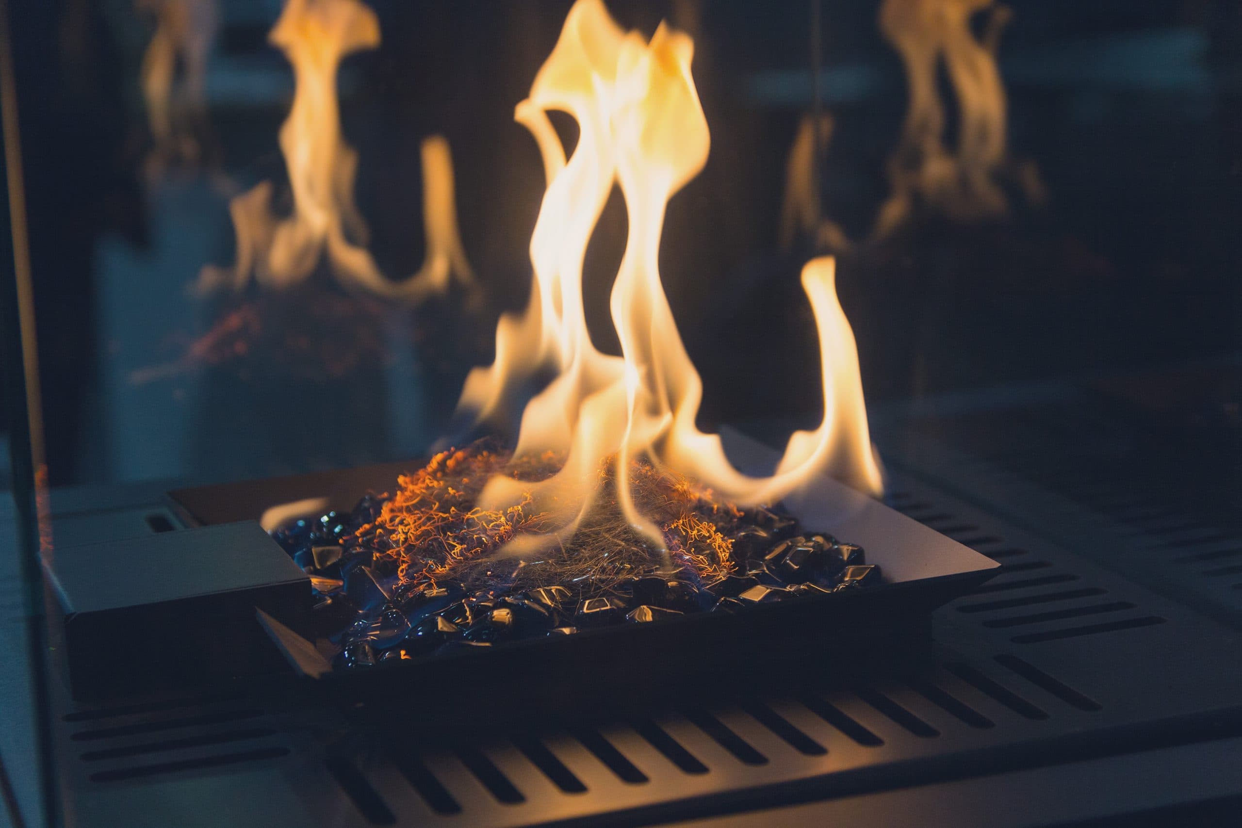 Flames over fire glass in a gas fireplace burner tray